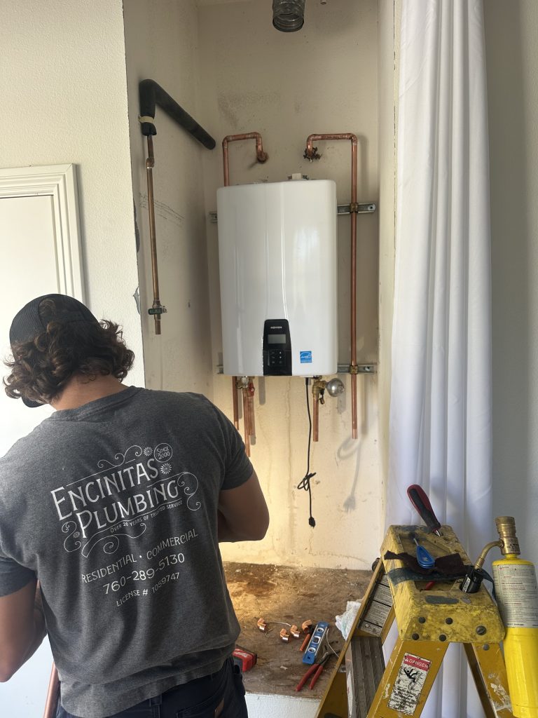 Licensed plumber installing Navien tankless water heater in North San Diego County