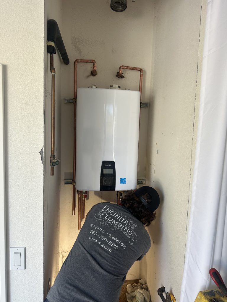 Licensed plumber installing Navien tankless water heater in North San Diego County